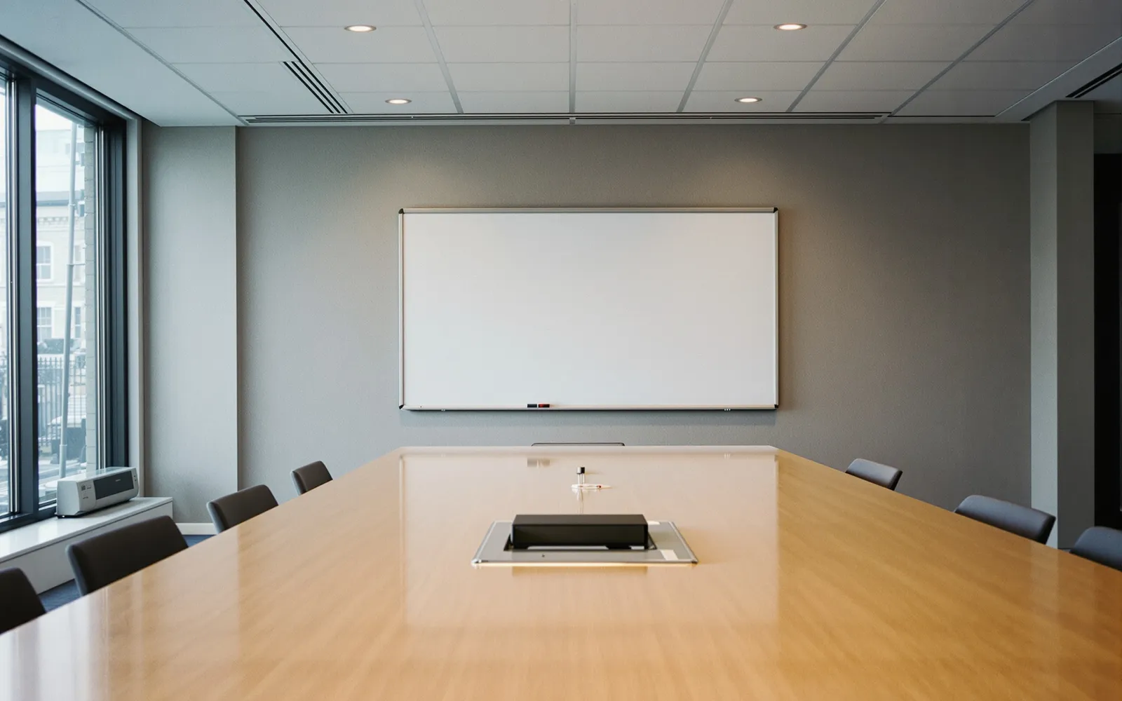 A boardroom mid-discussion, papers and laptops open on the table